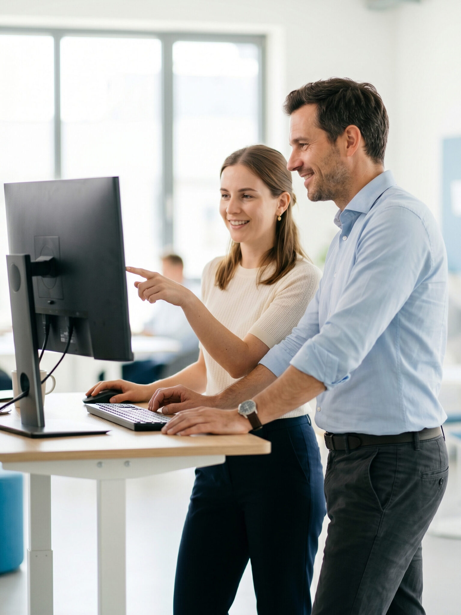 Two professionals working together at a computer – find B2B suppliers with Quodaris